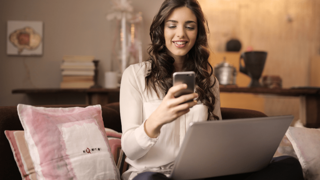 Woman using her phone and laptop